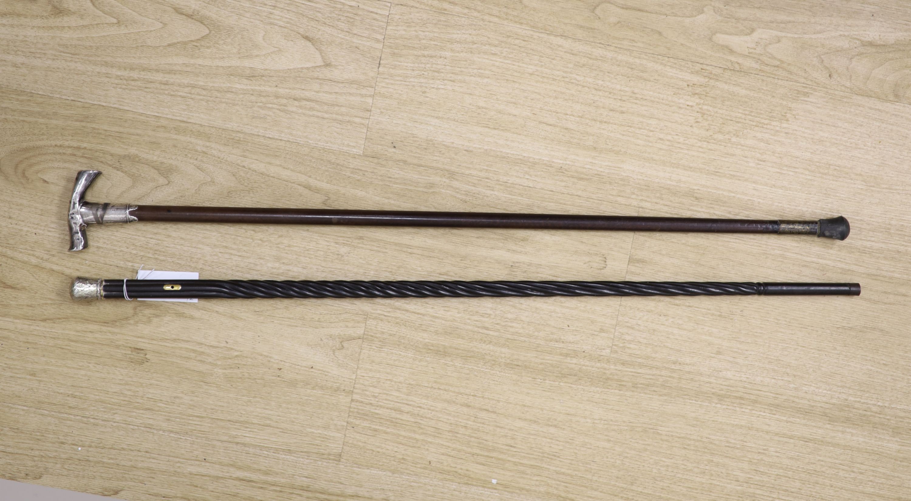 A 19th century Ceylonese ebony and silver topped walking stick and a white metal handled walking stick